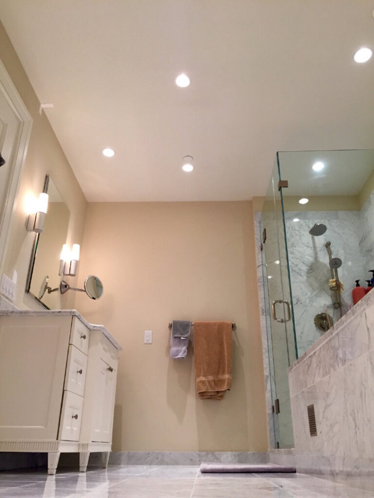 A modern bathroom featuring recessed lighting and wall sconces installed by GEN3 Electric & HVAC in Philadelphia, PA.