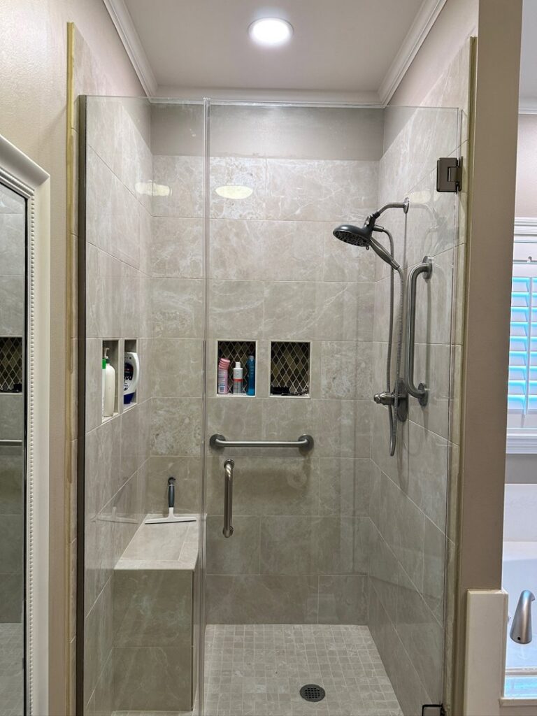 A recessed light installed above a tiled bathroom shower by LiveWire Electrical Services, LLC. in Houma, LA.