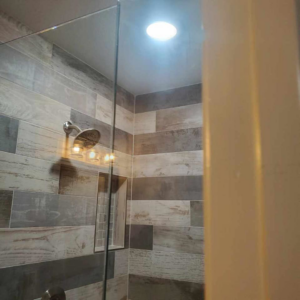 Modern bathroom shower with recessed ceiling light and vanity fixture installed by Triple JS & B Electric Inc. in Dallas, TX