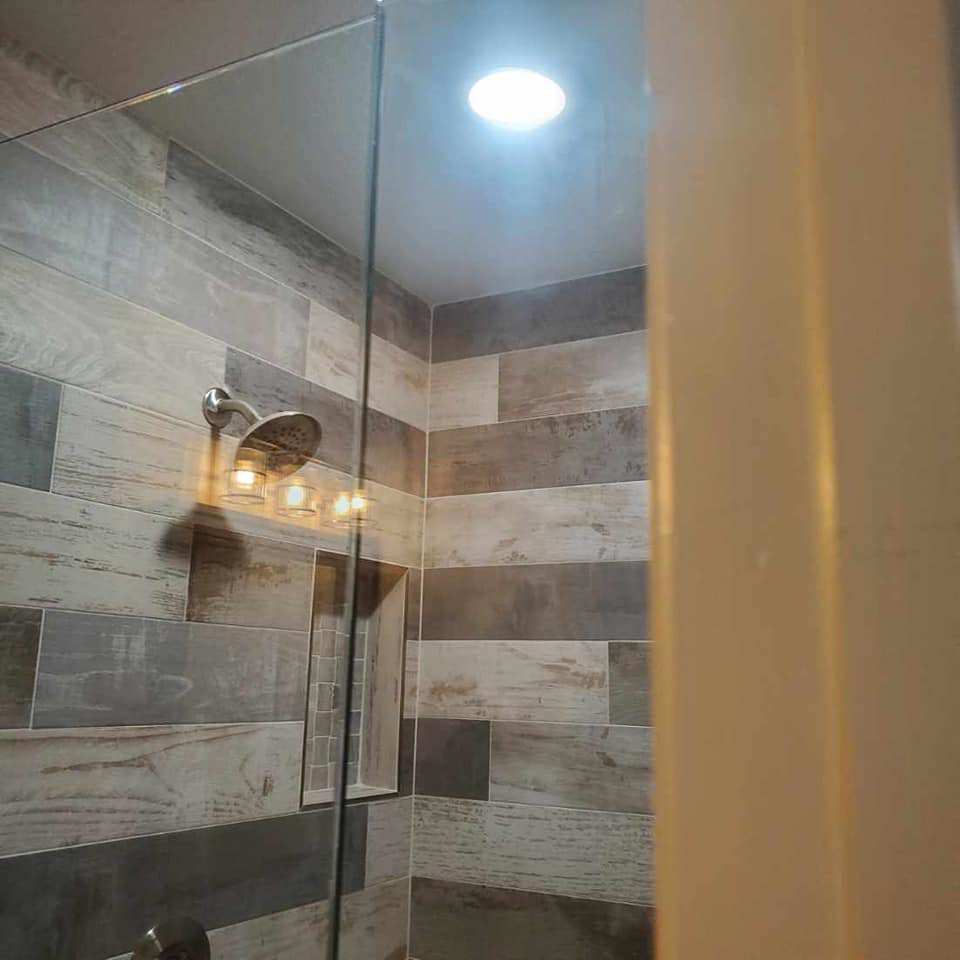 Modern bathroom shower with recessed ceiling light and vanity fixture installed by Triple JS & B Electric Inc. in Dallas, TX