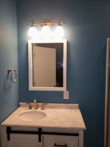 A newly installed bathroom vanity light fixture and electrical outlet by Fiedler Electric in Higginsville, MO.