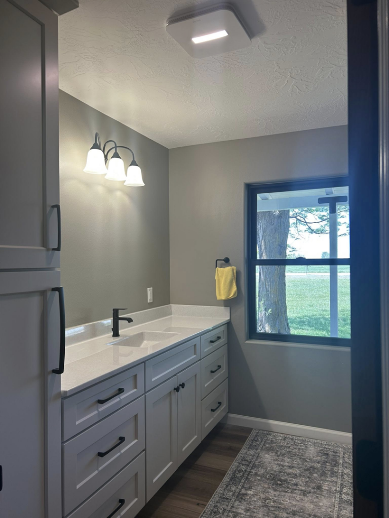 Bathroom vanity with a stylish light fixture and ceiling exhaust fan installed by Highmark Electric in Kearney, NE.