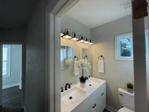 A newly installed vanity light fixture above a double sink in a bathroom by Denny Power Solutions in Virginia Beach, VA