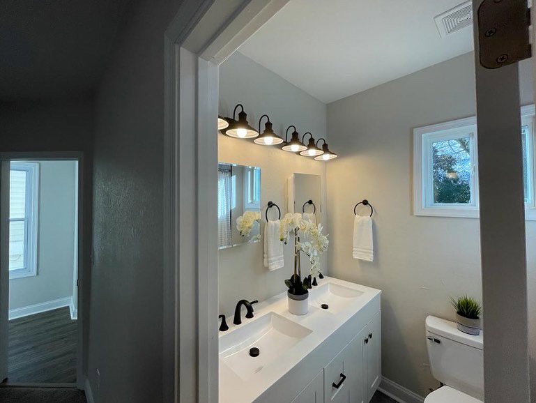 A newly installed vanity light fixture above a double sink in a bathroom by Denny Power Solutions in Virginia Beach, VA