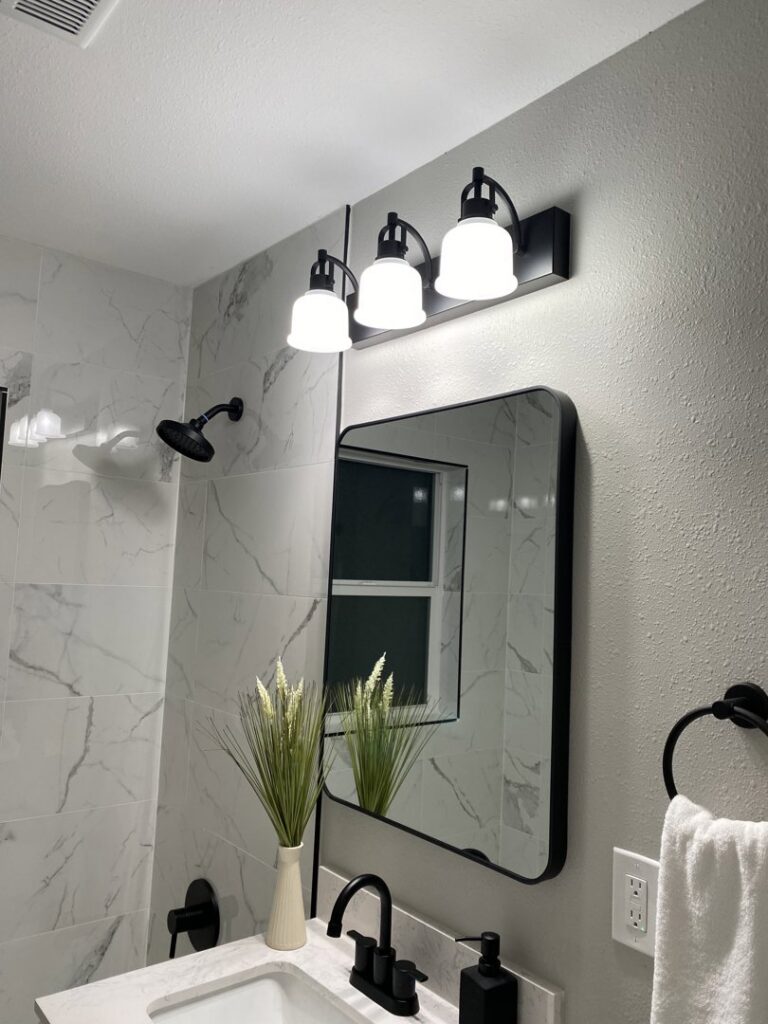 A modern bathroom vanity light fixture installed above a mirror by Good Contact Electric, LLC in Tacoma, WA.