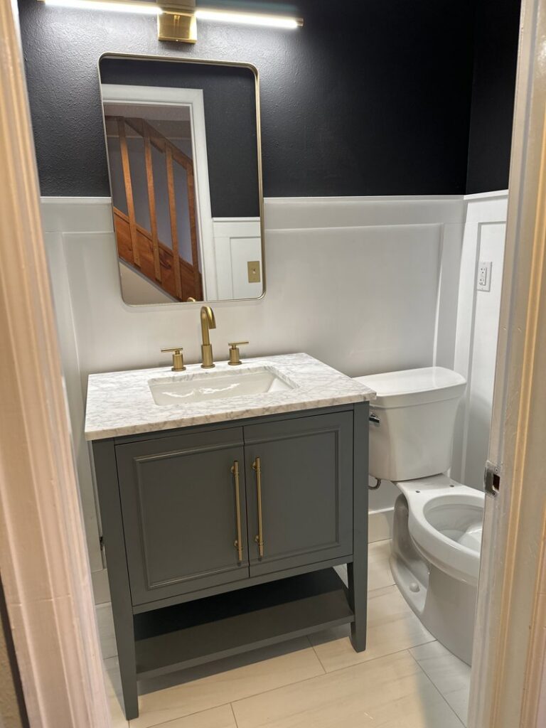 A newly installed light fixture above a bathroom vanity by Pulse Home Services in Denver, CO, showcasing electrical work.