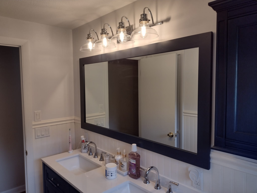 A newly installed bathroom vanity light fixture above a mirror by Steven Polom, Journeyman Electrician in Springfield, MA.