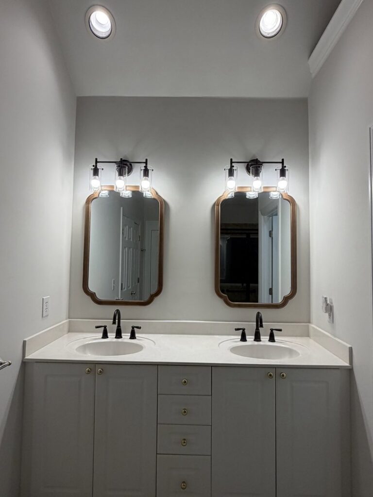 Newly installed bathroom vanity light fixtures above two sinks by Dr. Sparky in Nashville, TN