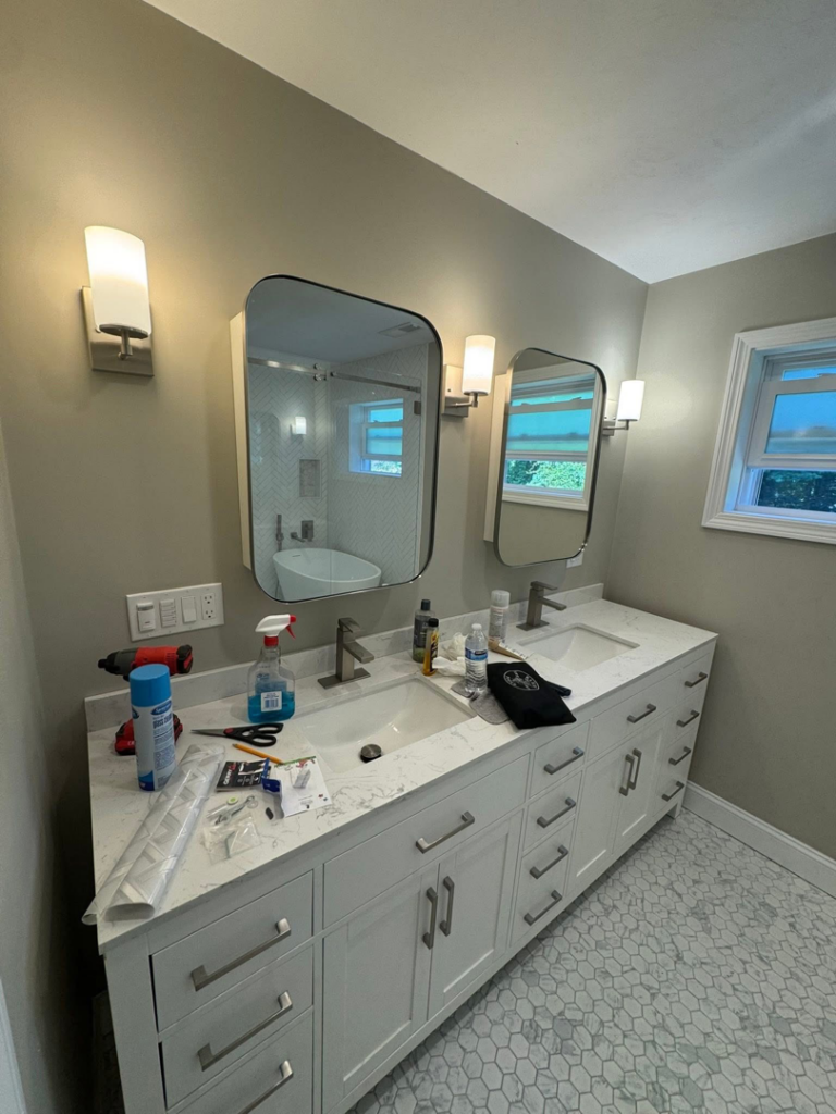 Bathroom vanity with new wall sconces and light switches, recently installed by P. Cruz Electric LLC in Springfield, MA.
