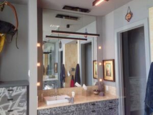 A bathroom vanity with modern linear lighting fixtures and accent wall lights installed by Christensen Electric in Galveston, TX.