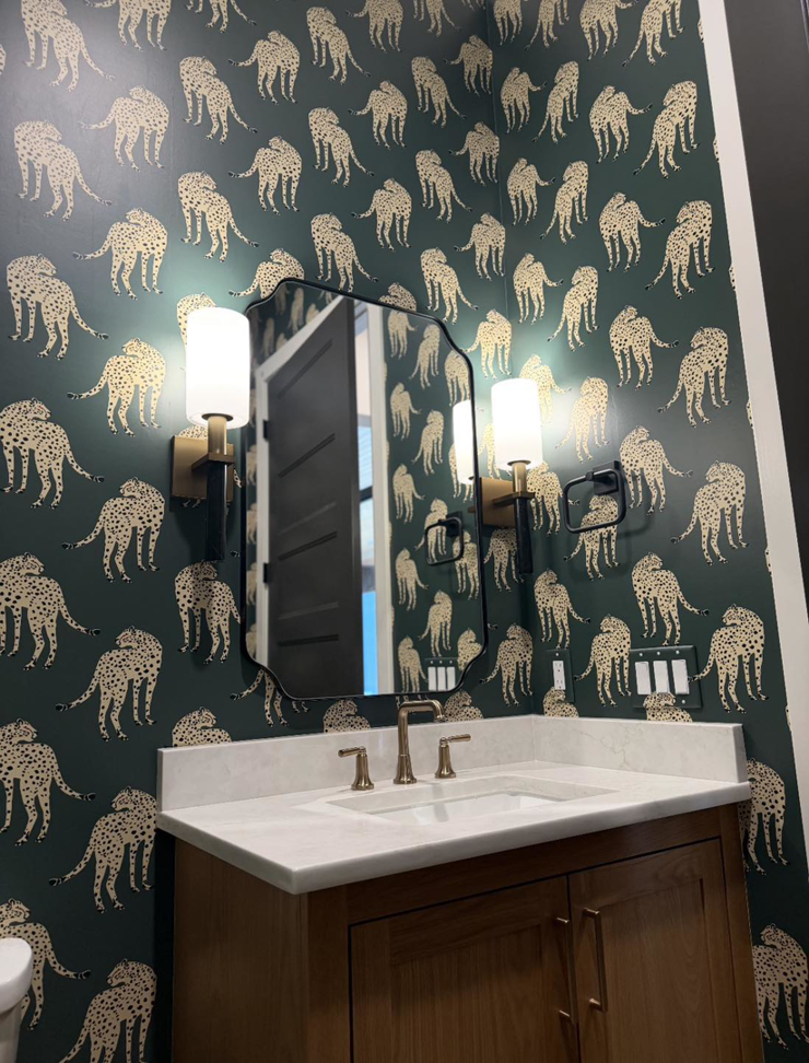 Wall sconces and an electrical outlet installed above a bathroom vanity by HMH Electric, serving Fayetteville, AR.