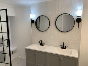 A bathroom vanity with newly installed wall sconces by Moss Contracting in Philadelphia, PA.