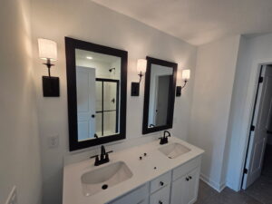 A modern bathroom vanity with two mirrors and stylish wall sconces installed by Kouris Electric LLC in Canton, OH.