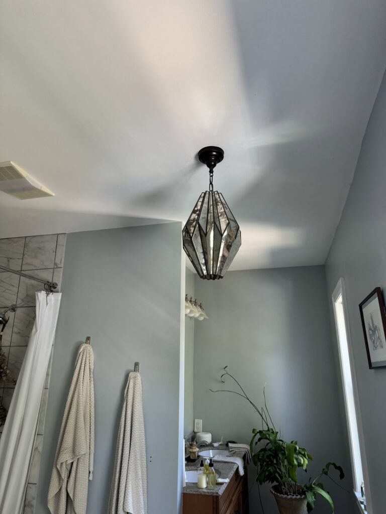 Bathroom with newly installed wall sconces and an electrical outlet by Border Electrical Contractor LLC in Nashua, NH.