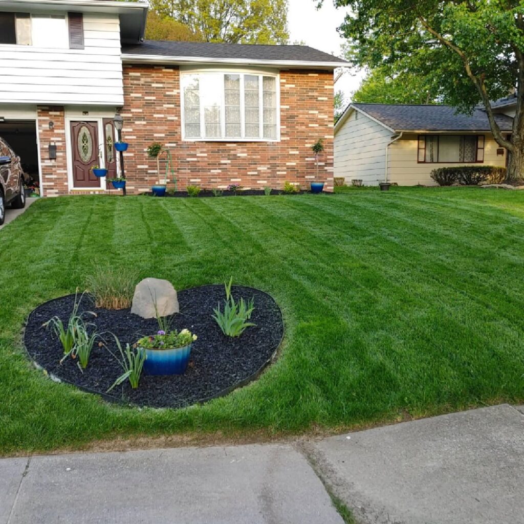 A beautiful, well-maintained, and striped front lawn after professional care from Mr. B's Lawn Aeration in Lafayette, IN.