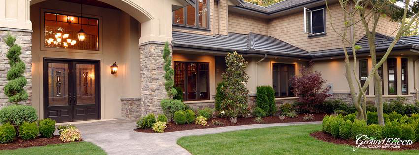 A beautifully landscaped front yard with a lush green lawn, showcasing work by Ground Effects Lawn Care in St. Louis, MO.