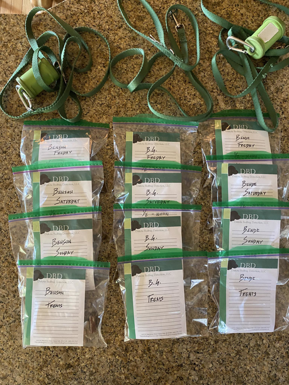 Organized bed bug detection dog supplies, including labeled food bags and leashes, for Dakota Bedbug Detection, LLC in Sioux Falls, SD.