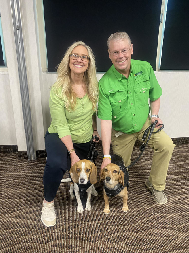 Two professional handlers kneeling with their bed bug detection dogs from Dakota Bedbug Detection, LLC in Sioux Falls, SD.