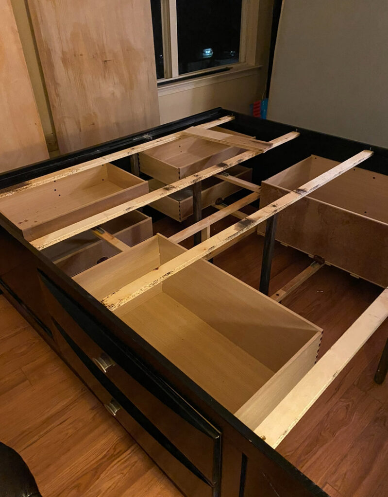 A bed frame with drawers removed, likely in preparation for a bed bug or pest treatment by Bed Bug and Pest Removal LLC in Baltimore, MD.