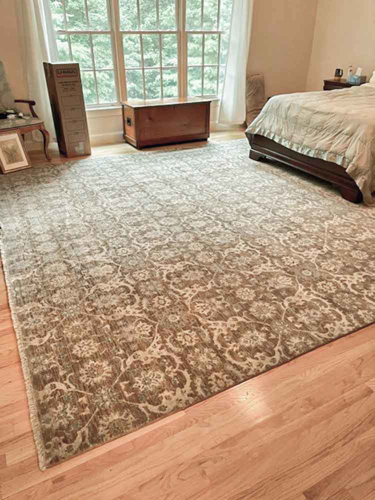 A large patterned area rug perfectly placed in a bedroom by Kaoud Rugs in West Hartford, CT.