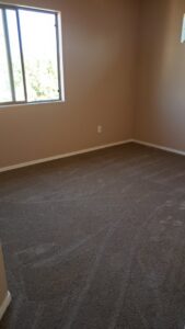A newly carpeted bedroom with brown plush carpet installed by Arizona Flooring wholesale center in Chandler, AZ.