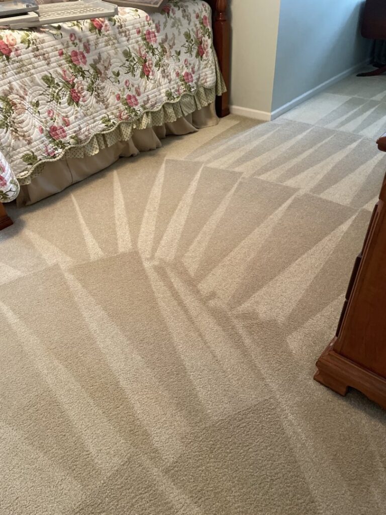 A bedroom carpet showing distinct cleaning lines after a professional service by Zerorez Greenville, SC.