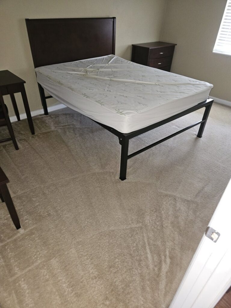 A clean, light-colored carpet with visible cleaning lines in a bedroom, showcasing professional carpet care by Hendry's Carpet Care in Tallahassee, FL.