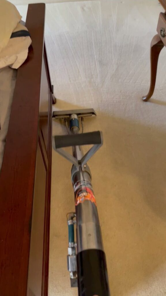 A carpet cleaning wand being used to clean a light-colored carpet in a bedroom by Specialty Carpet Care in Surprise, AZ