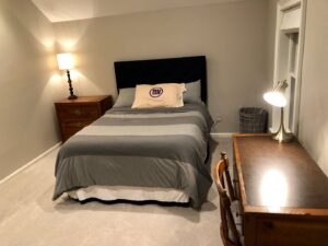 A cozy bedroom with new light gray carpet installed by Carpet King and Flooring in Myrtle Beach, SC.