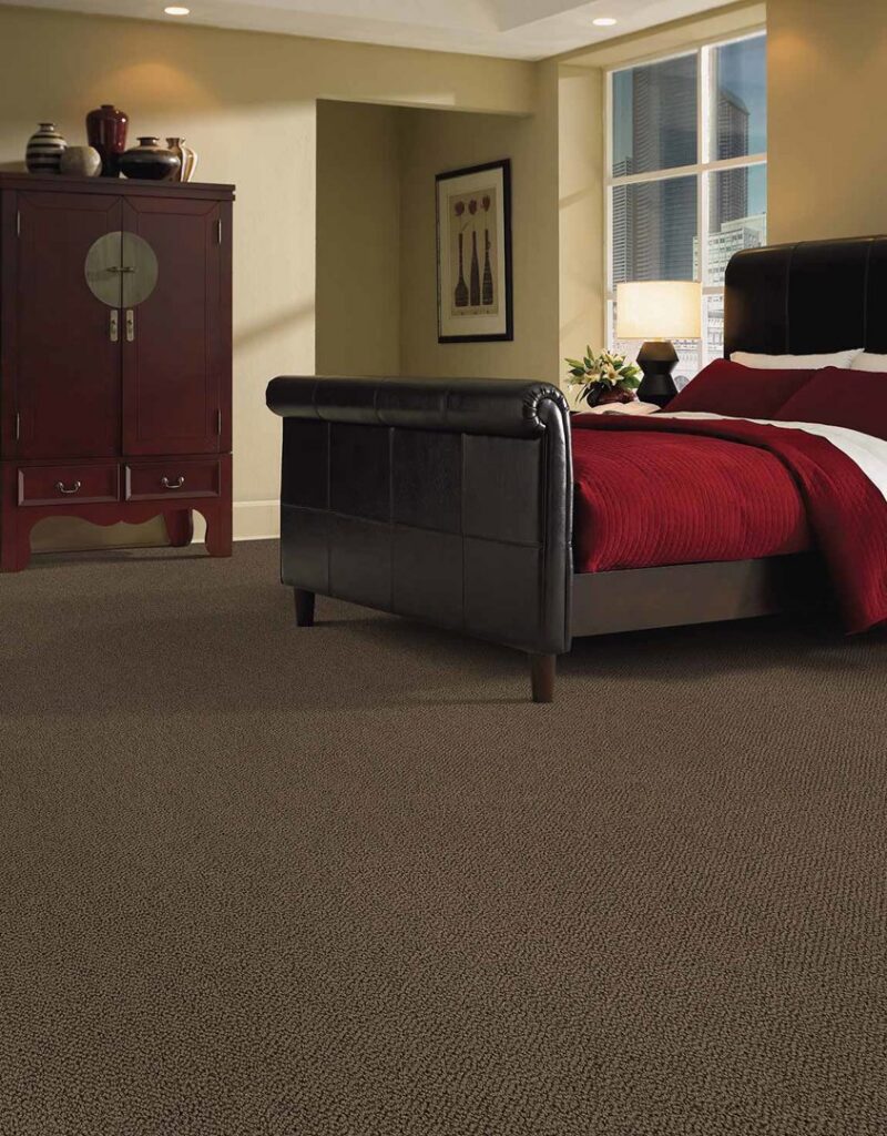 A beautifully installed dark brown carpet in a bedroom by Elite Flooring America in Decatur, AL.