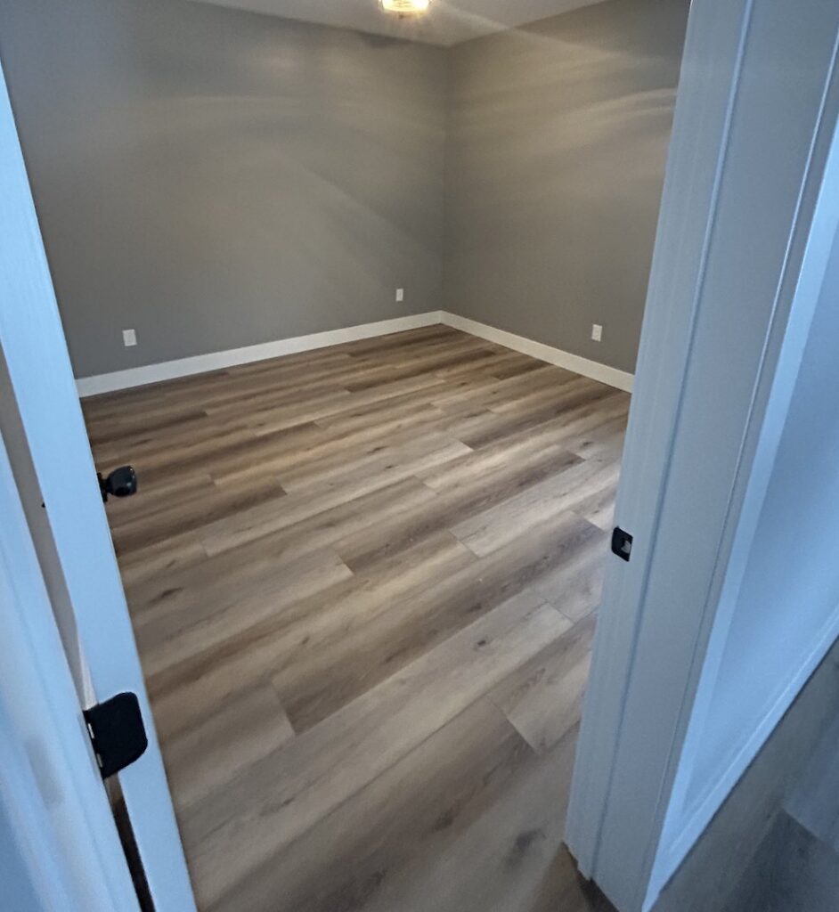 A bedroom with new gray carpet installed by Flooring World Wide LLC in Plainwell, MI.