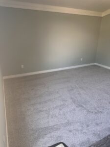 A bedroom showcasing new gray carpet installation, expertly done by Floors by Aldaba LLC in North Las Vegas, NV.