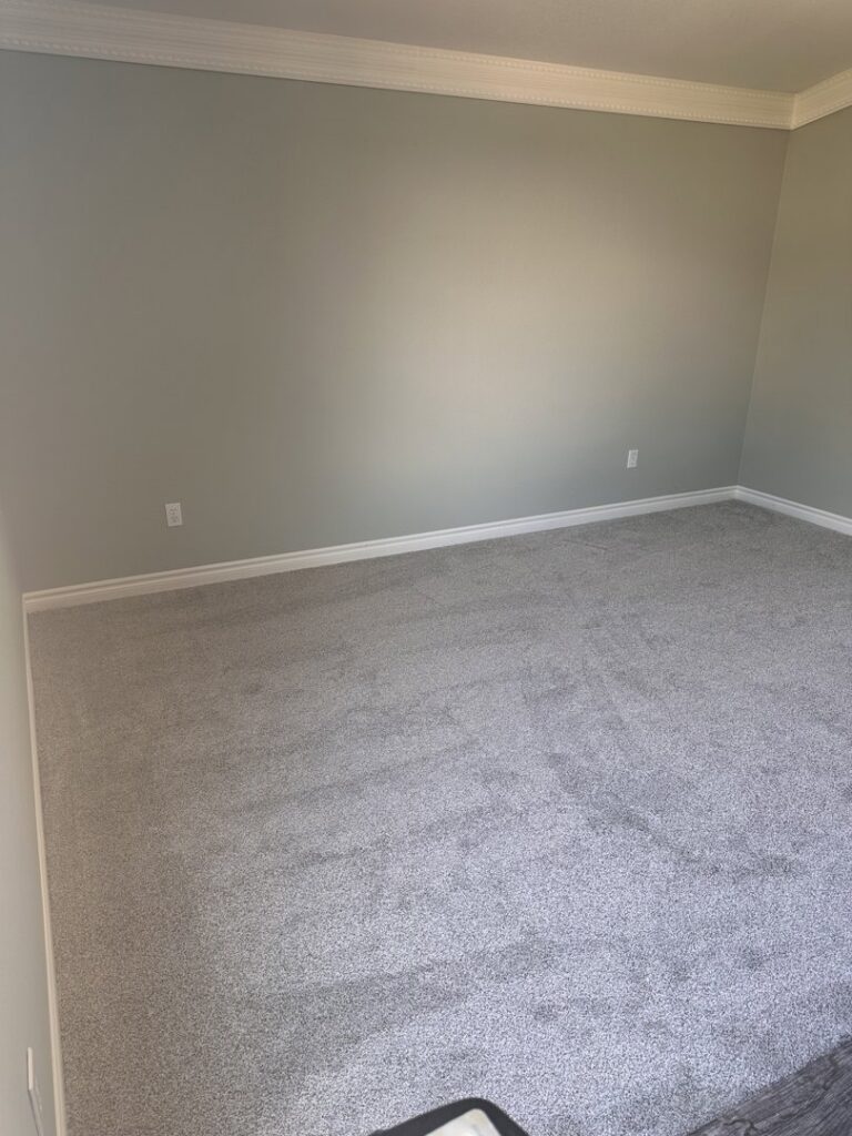 A bedroom showcasing new gray carpet installation, expertly done by Floors by Aldaba LLC in North Las Vegas, NV.
