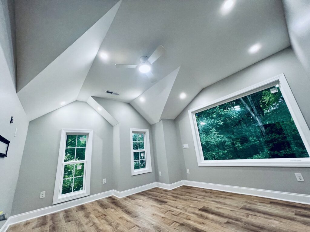 A bedroom with a newly installed ceiling fan and recessed lighting by Royal Electric Services in Raleigh, NC