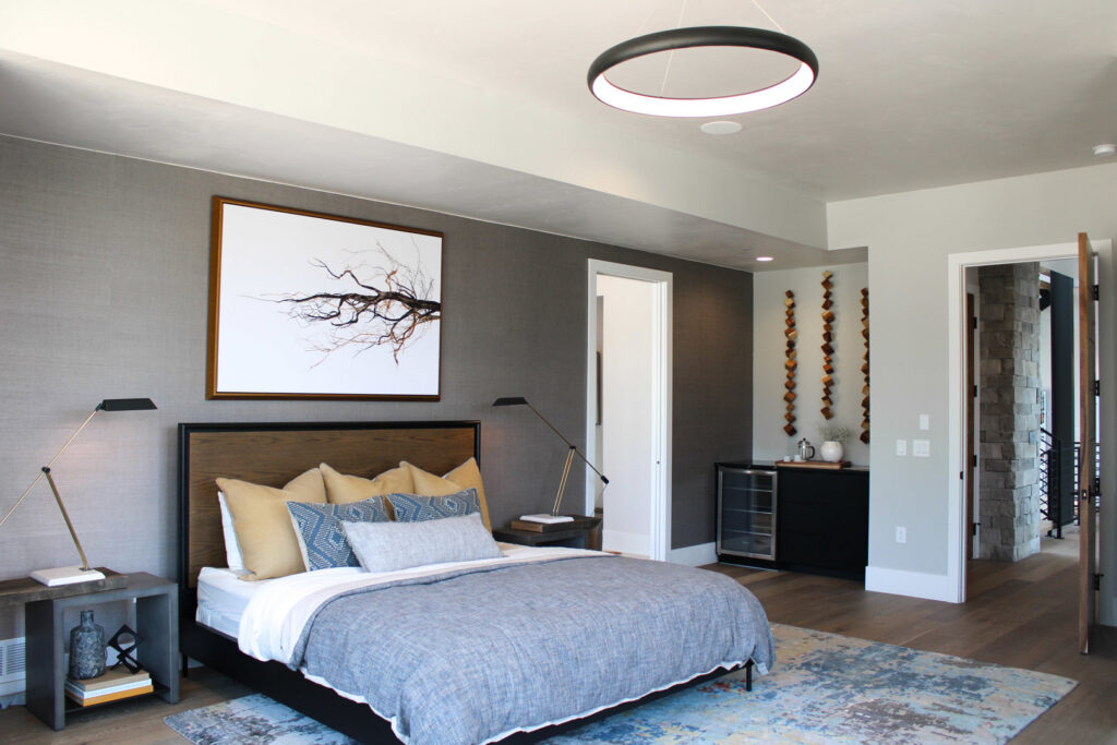 A modern bedroom featuring a large circular ceiling light and stylish bedside lamps installed by ACJ Electric LLC in North Babylon, NY.