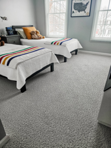 A cozy bedroom featuring a fresh grey carpet installation by Absolute Floor Covering, Inc in Kentwood, MI.