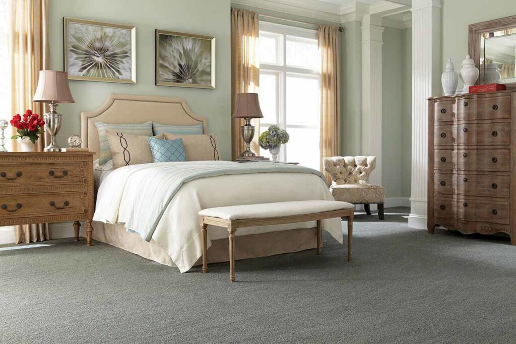 A cozy bedroom featuring new grey carpet installed by Pape's Flooring America in Pittsburgh, PA