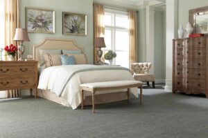A cozy bedroom featuring new grey carpet installed by Pape's Flooring America in Pittsburgh, PA