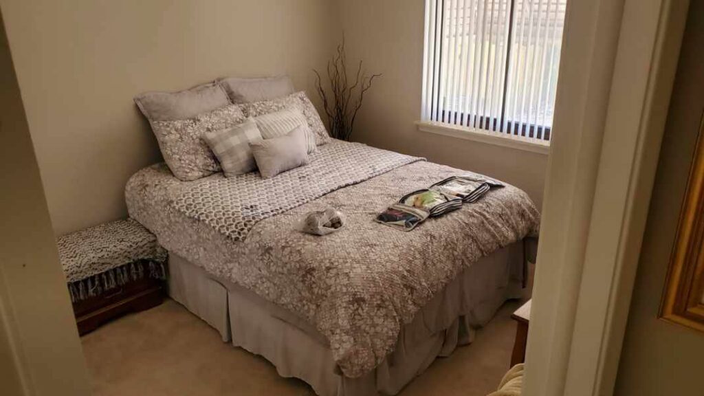 A comfortable bedroom showcasing new beige carpet installed by Son Shine Floor Covering LTD, a carpet contractor in Warren, MI.