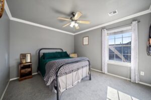 A bedroom featuring a new gray carpet installation, demonstrating the quality work of B A Carpet and Flooring in Broken Arrow, OK.