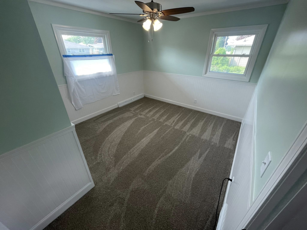 A bedroom with a new grey carpet installation by CDK Flooring, LLC in Sheboygan, WI.