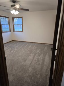 A bedroom featuring a freshly installed light grey carpet by Rosas Carpet & Flooring in Shorewood, IL.
