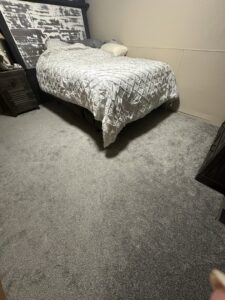 A bedroom showcasing newly installed plush grey carpet, expertly laid by Home Dynamics Flooring LLC in Harrisburg, SD.