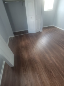 A bedroom with new vinyl plank flooring and a closet, installed by Harper's Floor's in Columbus, OH.
