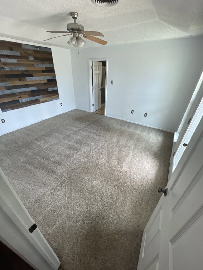 A bedroom with a clean carpet and ceiling fan after service by Alamogordo Carpet Cleaning in Alamogordo, NM.