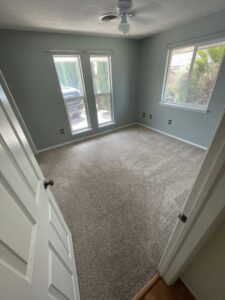 A bedroom with a clean carpet and bright windows, showcasing work by Alamogordo Carpet Cleaning in Alamogordo, NM.