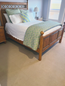 A cozy bedroom featuring a new light-colored carpet installation by Gene's Floor Covering II in Gulf Shores, AL.