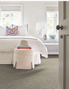 A cozy bedroom featuring newly installed light grey carpet by Floors Etcetera, Inc. in Houston, TX.