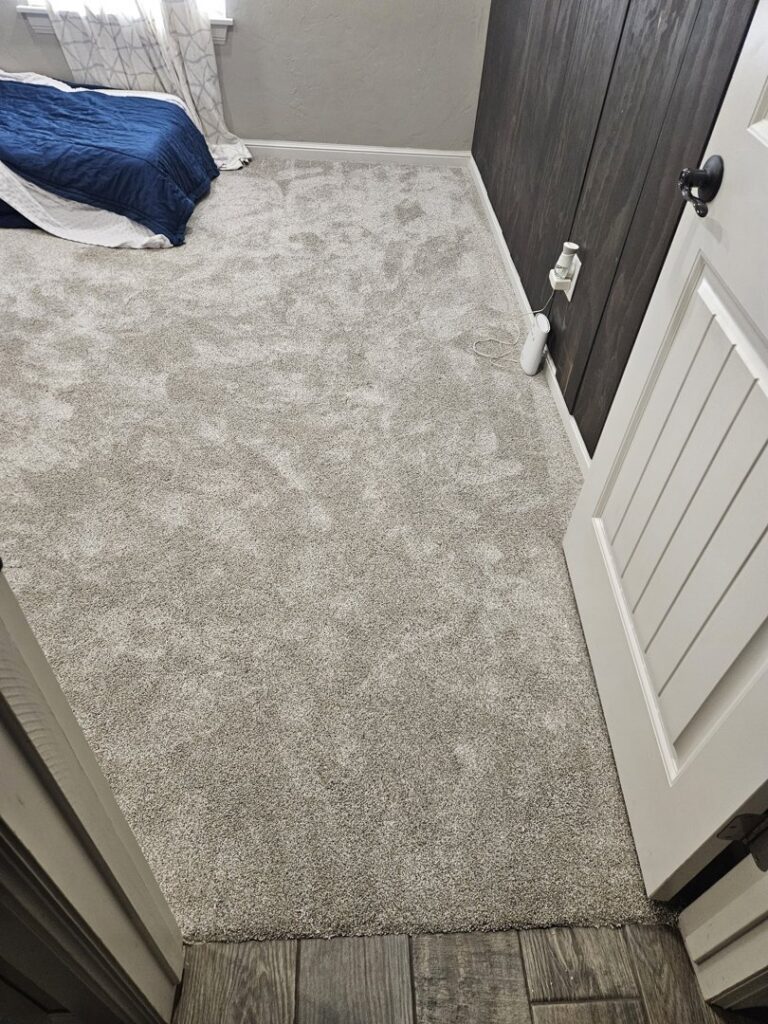 A bedroom featuring newly installed grey carpet, a completed project by Don's Floor Gallery in Edmond, OK.