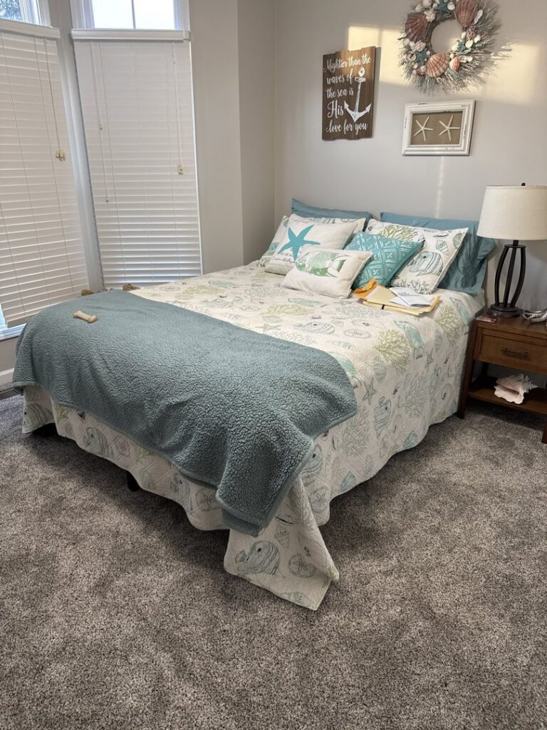 A bedroom featuring newly installed grey carpet by Volunteer Flooring & Design in Knoxville, TN.